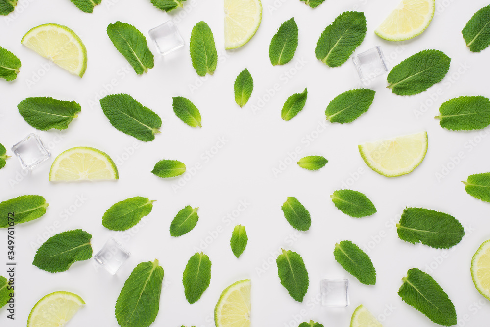 Top above overhead view photo of mint leaves, ice-cubes and lime slices lying in circles with empty center isolated on white background Top above overhead view photo of mint leaves, ice-cubes and lime slices lying in circles with empty center isolated on white background