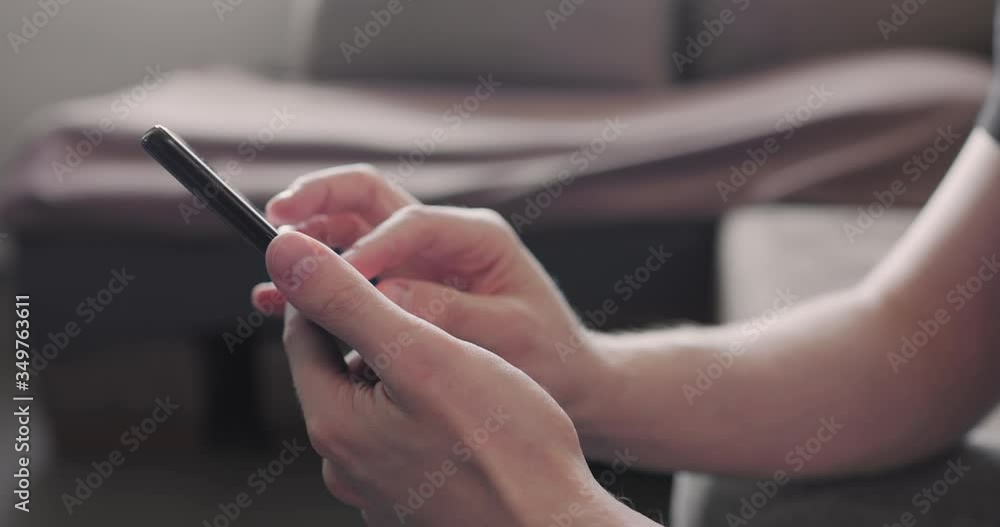 Closeup young man use smartphone working from home side view Closeup young man use smartphone working from home side view