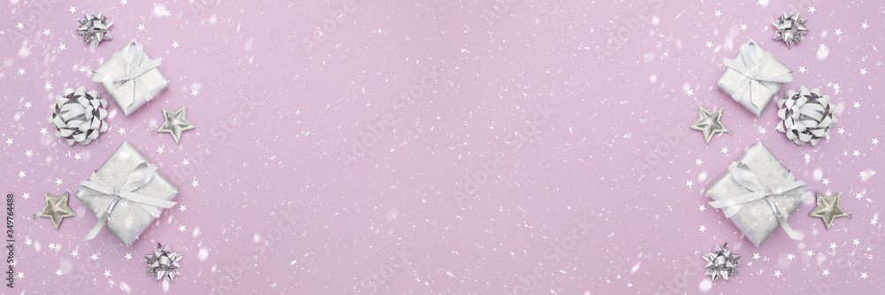 Banner of gifts or present boxes in silver with silver bows and tree ball ornaments and little silver stars, table top view, snowflakes. Composition for Christmas. Rose pink pastel background. Banner of gifts or present boxes in silver with silver bows and tree ball ornaments and little silver stars, table top view, snowflakes. Composition for Christmas. Rose pink pastel background.