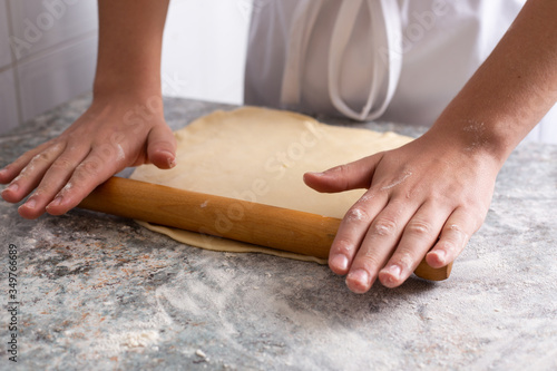 Baker stretches the dough with rolling pins