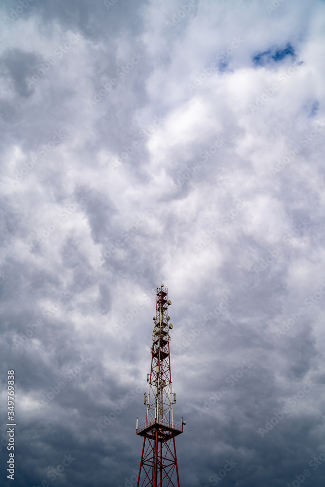 Telecommunication tower on cloud sky background