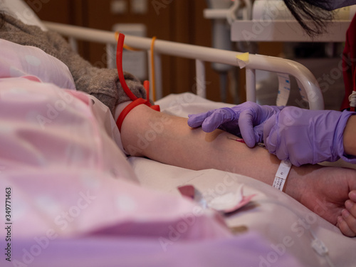 A nurse inserting a canula into a patient's arm photo