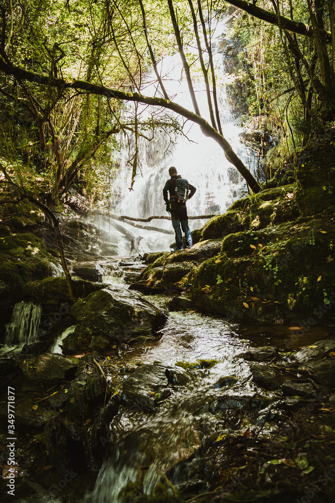 Man front of a waterfall in the forest