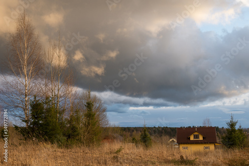 Panorama of village on Klin-Dmitrovsky ridge with clouds in early spring, Sergiev Posad district, Moscow region, Russia