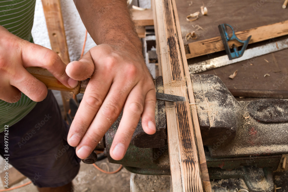Male carpenter working on old wood in a retro vintage workshop. Male carpenter working on old wood in a retro vintage workshop.
