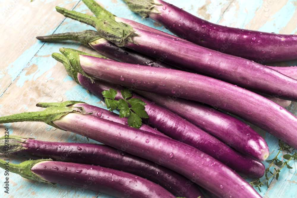 top view of fresh purple japanese eggplants on rustic wooden background top view of fresh purple japanese eggplants on rustic wooden background
