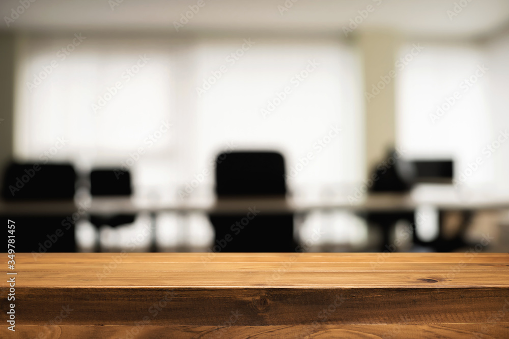 Empty wooden desk space over blurred office or meeting room background. Product display. Empty wooden desk space over blurred office or meeting room background. Product display.