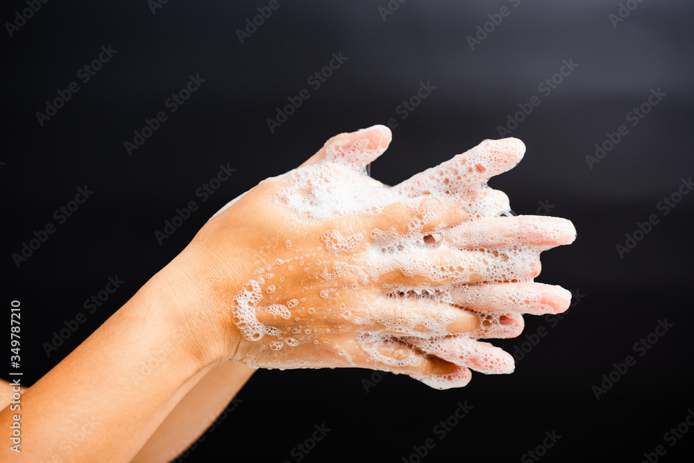 Closeup body care Asian young woman washing hands with soap have foam, hygiene prevention COVID-19 or coronavirus protection concept, isolated on black background Closeup body care Asian young woman washing hands with soap have foam, hygiene prevention COVID-19 or coronavirus protection concept, isolated on black background