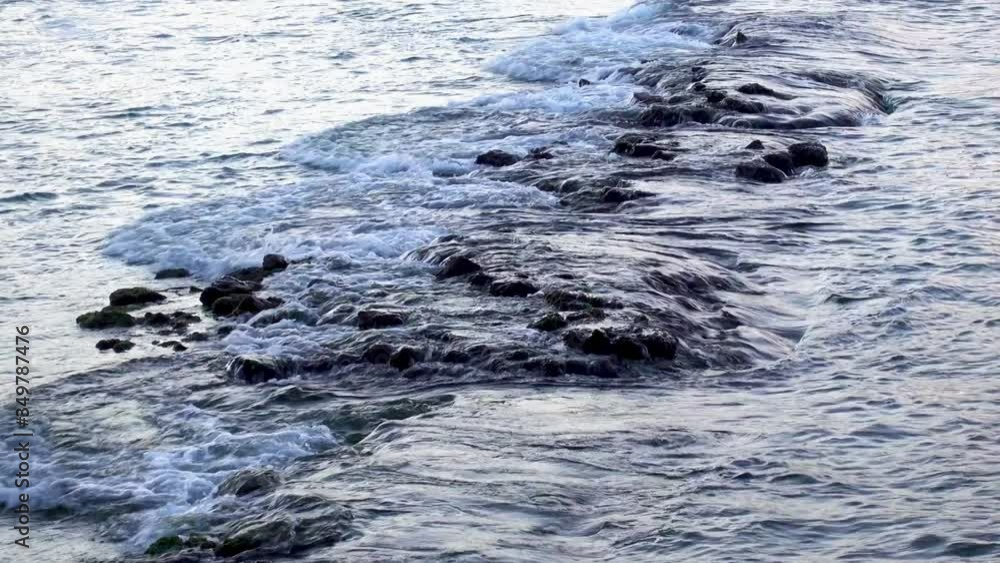 Sea wave gently washing a stone reef on the coast Sea wave gently washing a stone reef on the coast