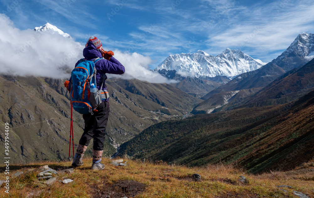 Woman hiker use calling mobile phone on hight altitude at mount Everest view point