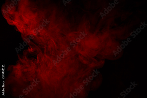 Colorful smoke close-up on a black background. Red cloud of smoke.