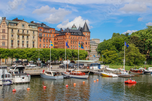 center of the Scandinavian capital of Stockholm with smooth bay water, promenade, yachts and houses. Scandinavian architecture of cities. #349801632