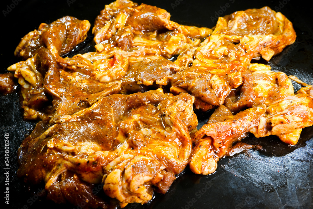 A picture of marinated black pepper and herbs mutton on black tray.