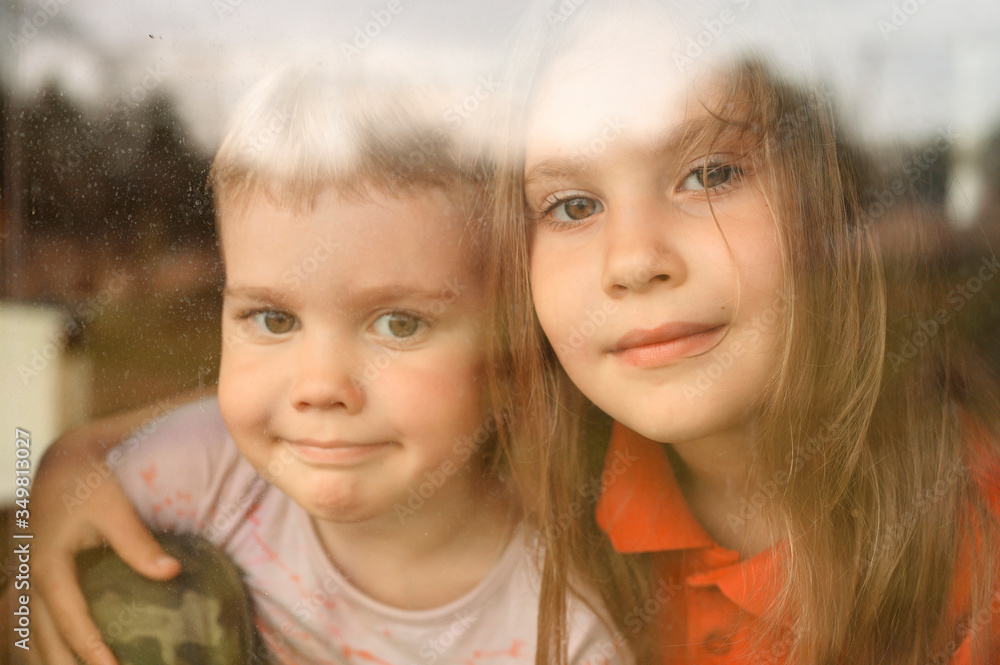 kids siblings boy and girl looks through the window during covid-19 quarantine. stay at home, let's all be well kids siblings boy and girl looks through the window during covid-19 quarantine. stay at home, let's all be well