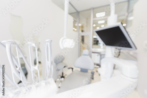 Blurred modern empty dental chair with professional equipment
