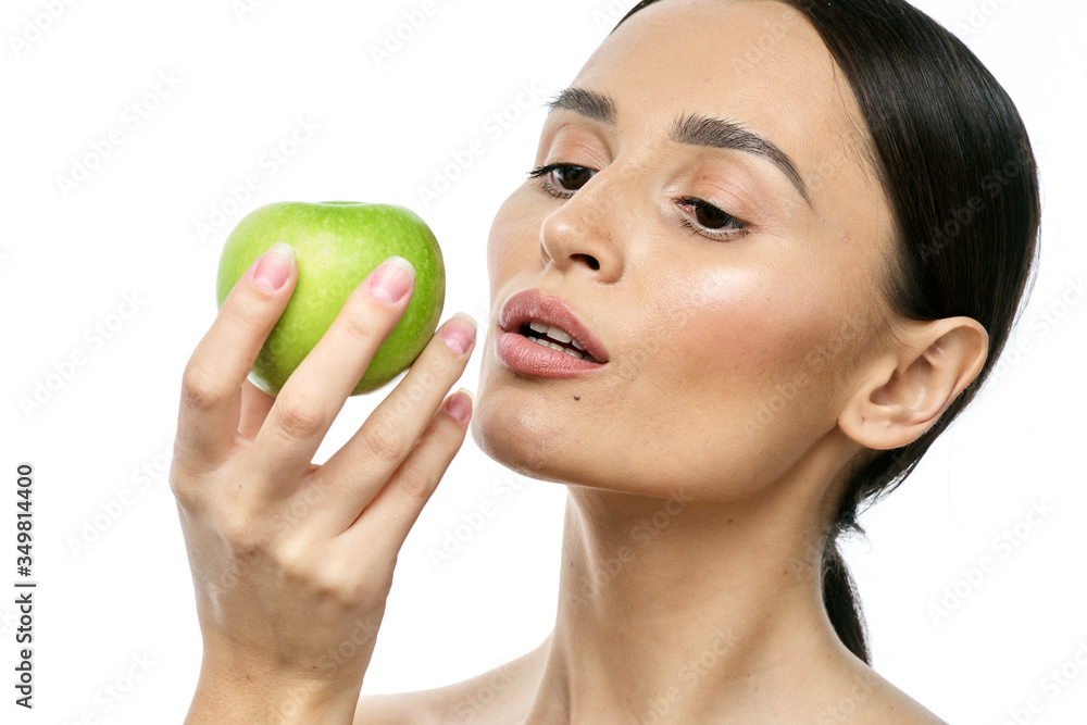 close-up portrait of a girl with clear skin holding a apple to her face, isolated on a white background close-up portrait of a girl with clear skin holding a apple to her face, isolated on a white background