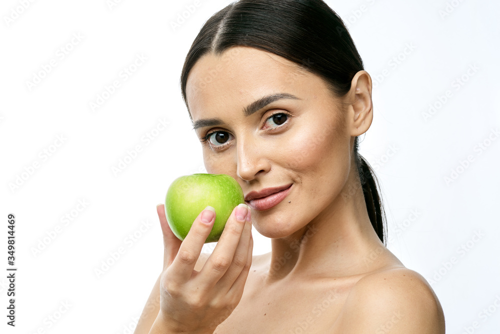 close-up portrait of a girl with clear skin holding a apple to her face, isolated on a white background close-up portrait of a girl with clear skin holding a apple to her face, isolated on a white background