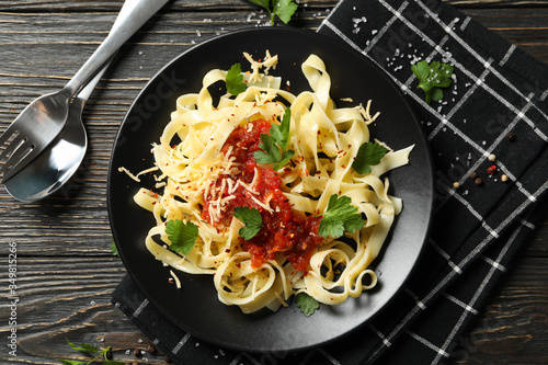 Composition with plate of tasty pasta on wooden background