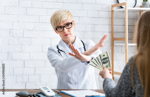 Free doctor consultation. Woman makes gesture with hands, refusal of money photo