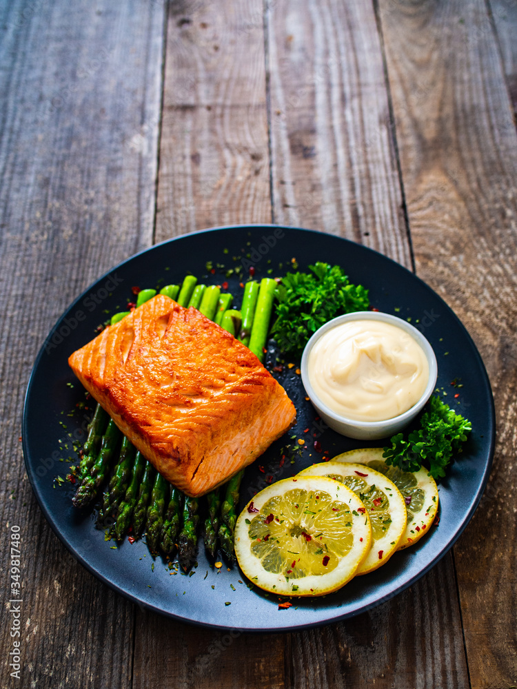 Fried salmon and asparagus on wooden table Fried salmon and asparagus on wooden table