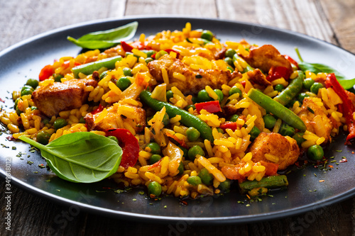 Konstfotografi Paella chicken on wooden background