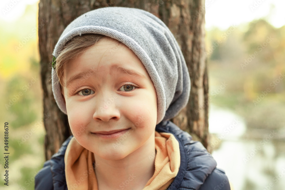 portrait of a boy on a background of a tree in the forest, the boy is happy and smiling portrait of a boy on a background of a tree in the forest, the boy is happy and smiling