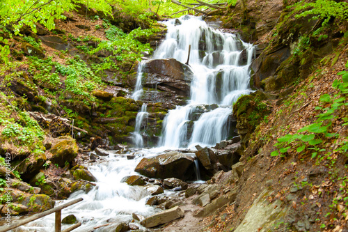 Fototapeta Naklejka Na Ścianę i Meble -  large spring waterfall with green leaves