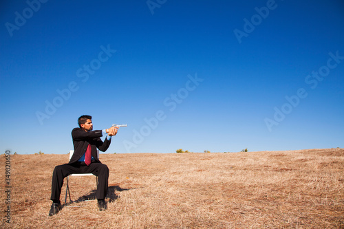 Businessman aiming a handgun © Helder Almeida