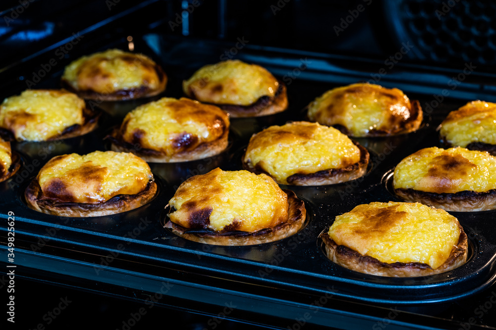 Pasteis de Nata or Belem Tart. Portuguese Custard made with Egg, Cinnamon, Sugar and Flour in Muffin Tray / Cupcake Mol in Oven. Pasteis de Nata or Belem Tart. Portuguese Custard made with Egg, Cinnamon, Sugar and Flour in Muffin Tray / Cupcake Mol in Oven.