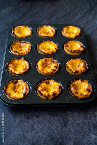 Pasteis de Nata or Belem Tart. Portuguese Custard made with Egg, Cinnamon, Sugar and Flour in Muffin Tray / Cupcake Mold.