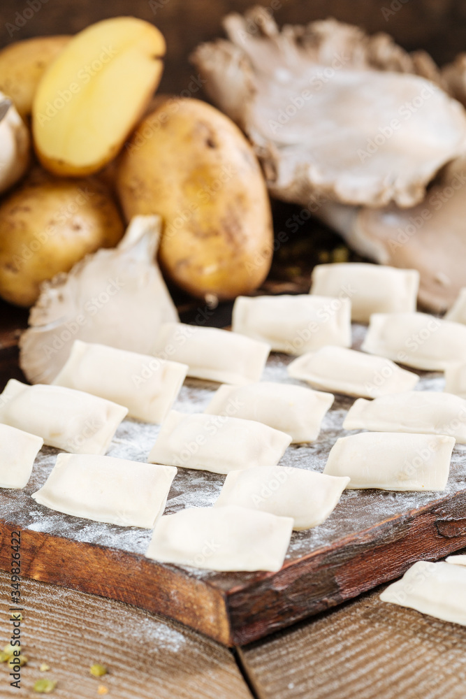 raw dumplings with potatoes and mushrooms on the board raw dumplings with potatoes and mushrooms on the board