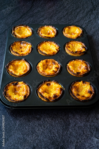 Pasteis de Nata or Belem Tart. Portuguese Custard made with Egg, Cinnamon, Sugar and Flour in Muffin Tray / Cupcake Mold.