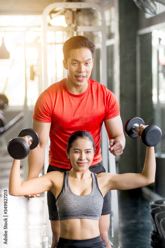 Fototapeta premium The trainer is teaching exercise to charming women Dumbbell Lifting Course for Strengthens Muscles, Online Live Streaming, Exercise Tutorials, Exercise Concept at Home.