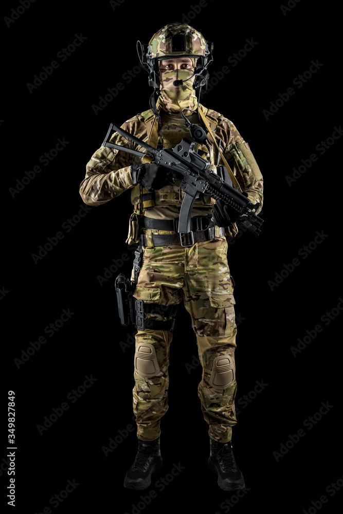 Soldier holding assault rifle. Uniform conforms to special services of the Russian Federation. Shot in studio. Isolated with clipping path on black background Soldier holding assault rifle. Uniform conforms to special services of the Russian Federation. Shot in studio. Isolated with clipping path on black background