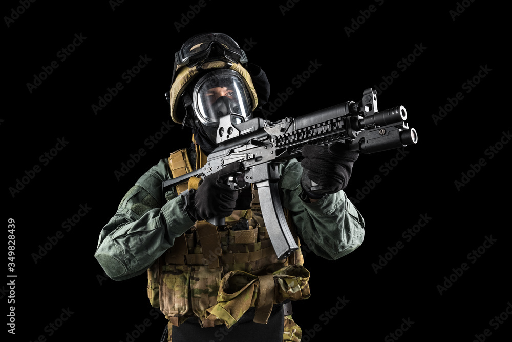 Soldier holding assault rifle. Uniform conforms to special services of the Russian Federation. Shot in studio. Isolated with clipping path on black background Soldier holding assault rifle. Uniform conforms to special services of the Russian Federation. Shot in studio. Isolated with clipping path on black background