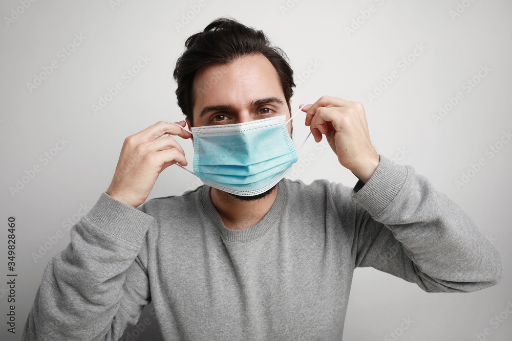 Portrait of young man using medical virus mask protection of coronavirus. Worldwide pandemic situation. Space for text. Portrait of young man using medical virus mask protection of coronavirus. Worldwide pandemic situation. Space for text.