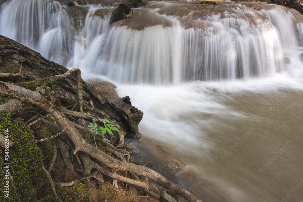 Fototapeta premium Waterfall in the jungle of central region Thailand. Low shutter speed stream.