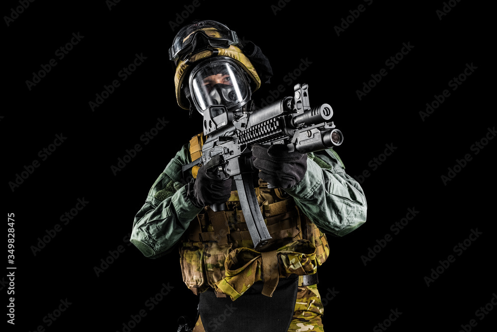 Soldier holding assault rifle. Uniform conforms to special services of the Russian Federation. Shot in studio. Isolated with clipping path on black background Soldier holding assault rifle. Uniform conforms to special services of the Russian Federation. Shot in studio. Isolated with clipping path on black background