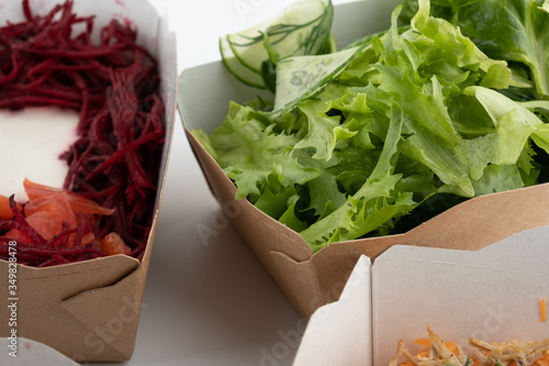 a set of different salads for vegetarians and raw foodists ready to eat in cardboard plates photo