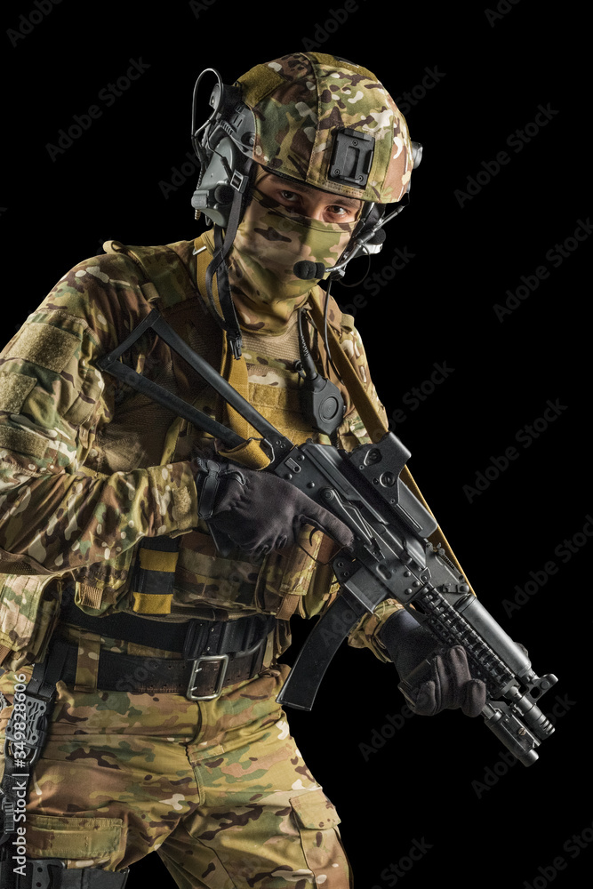 Soldier holding assault rifle. Uniform conforms to special services of the Russian Federation. Shot in studio. Isolated with clipping path on black background Soldier holding assault rifle. Uniform conforms to special services of the Russian Federation. Shot in studio. Isolated with clipping path on black background
