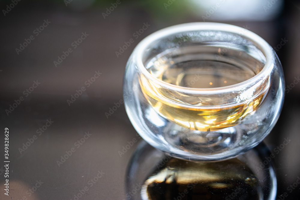 The syrup in clear cup on mirror surface with reflection. The syrup in clear cup on mirror surface with reflection.