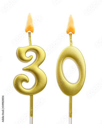 Burning golden birthday candles isolated on white background, number 30