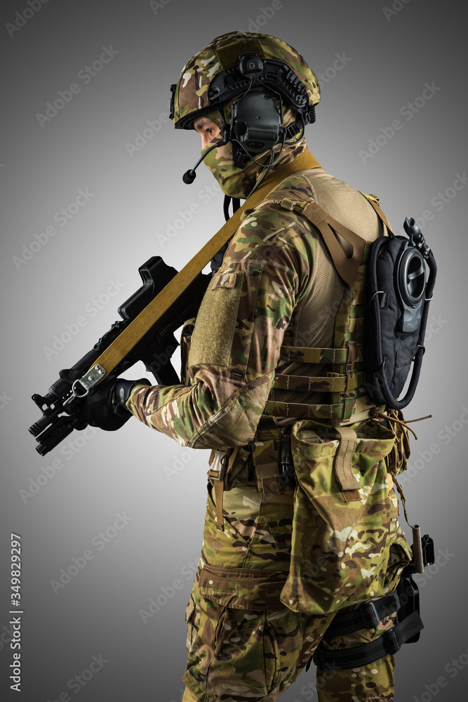Soldier holding assault rifle. Uniform conforms to special services of the Russian Federation. Shot in studio. Isolated with clipping path on grey background Soldier holding assault rifle. Uniform conforms to special services of the Russian Federation. Shot in studio. Isolated with clipping path on grey background