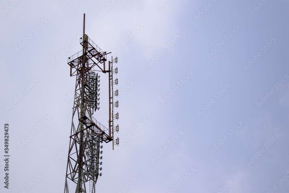 Mast of an old transmitting antenna complex. Metal construction of broadcasting. Sky with clouds. Mast of an old transmitting antenna complex. Metal construction of broadcasting. Sky with clouds.