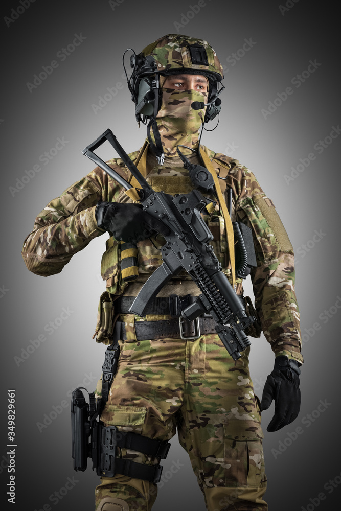 Soldier holding assault rifle. Uniform conforms to special services of the Russian Federation. Shot in studio. Isolated with clipping path on grey background Soldier holding assault rifle. Uniform conforms to special services of the Russian Federation. Shot in studio. Isolated with clipping path on grey background