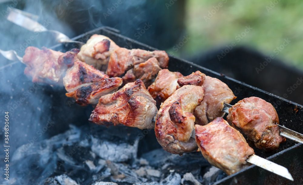 The meat on skewers is fried on the grill.