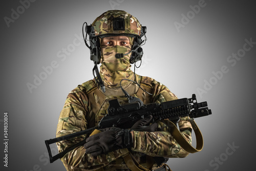 Soldier holding assault rifle. Uniform conforms to special services of the Russian Federation. Shot in studio. Isolated with clipping path on grey background