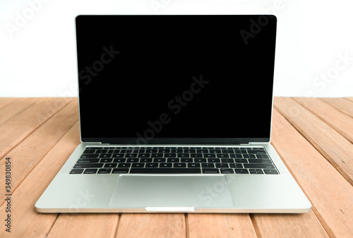 Laptop with black screen on wooden table.  Object for technology