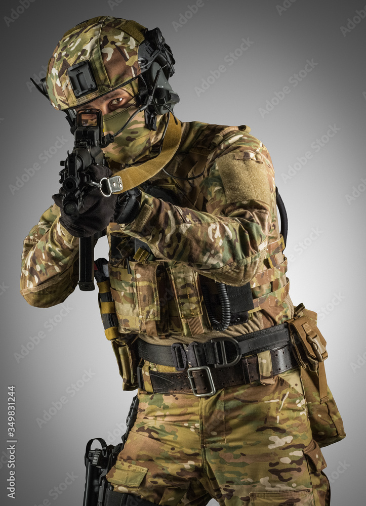 Soldier holding assault rifle. Uniform conforms to special services of the Russian Federation. Shot in studio. Isolated with clipping path on grey background Soldier holding assault rifle. Uniform conforms to special services of the Russian Federation. Shot in studio. Isolated with clipping path on grey background