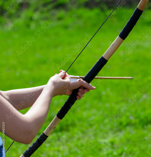 Girl shoots a bow in the park. © schankz